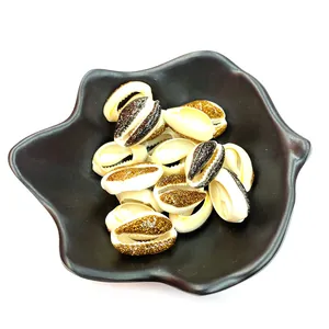 Natural bleached seashells with gold and black glitter in a black ceramic leaf dish