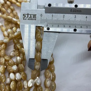 Makroaufnahme eines Messschiebers zur Messung einer Naturschale-Perle für DIY-Schmuck