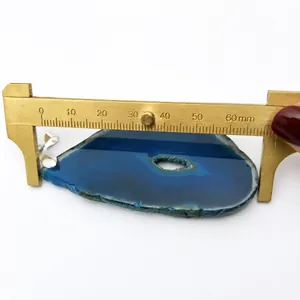 Detail shot showing a 62mm blue agate slice pendant measured with a brass caliper