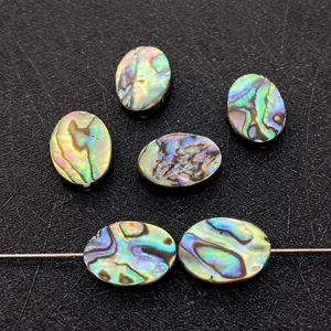 Macro shot of oval abalone shell beads showing vibrant colorful iridescence and luster