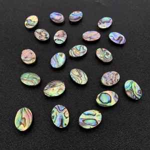 Macro shot of oval iridescent abalone shell beads showing natural colorful luster on black base