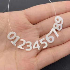 Detail von weißen 0-9 muschelähnlichen Nummer-Perlen für DIY Schmuck und Halsketten