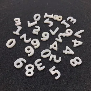 Makro-Detail von weißen Süßwassermuschel-Perlen mit gravierten schwarzen Zahlen 0 bis 9