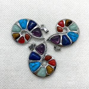 Macro view of silver snail-shaped pendants featuring seven chakra natural gemstones