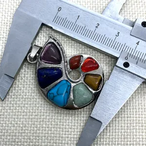 Macro view of spiral shell pendant with chakra stones measured by a caliper