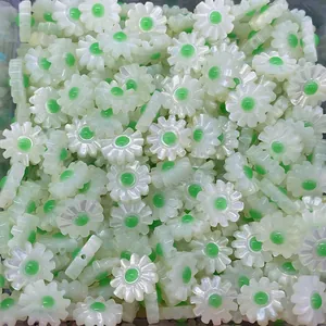Macro detail of pearlescent white daisy beads with green centers for DIY jewelry making