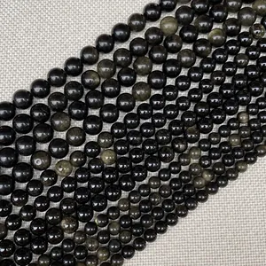Macro de perles d'obsidienne noire polies avec reflets dorés pour création bijoux