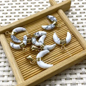 Détail macro du pendentif demi-lune avec texture marbre blanc et fermoir doré chic