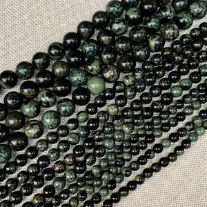 Detalle de cuentas redondas de piedra natural verde en varios tamaños para joyería DIY