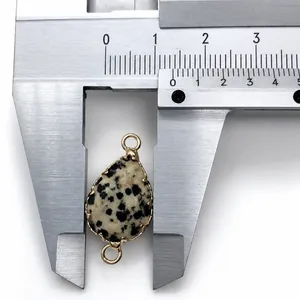 Macro shot measuring 14mm teardrop Dalmatian Jasper connector with gold plated edges