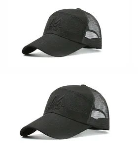 Detail view of black trucker hat featuring mesh back and 3D embroidered M logo