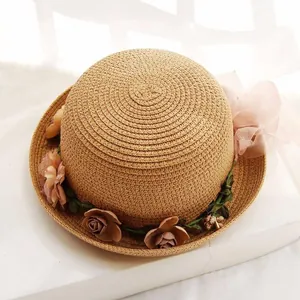 Detail of hand-woven straw hat with 3D floral accents and a large translucent pink bow