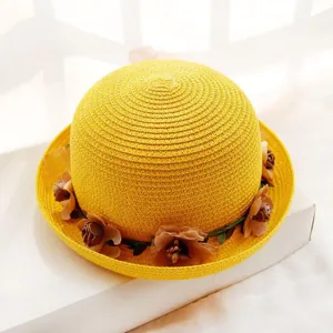 Macro view of woven straw hat featuring vibrant yellow texture and brown floral trim