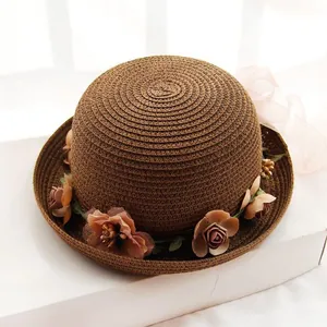 Close-up of woven straw hat featuring detailed vintage floral trim and spiral texture