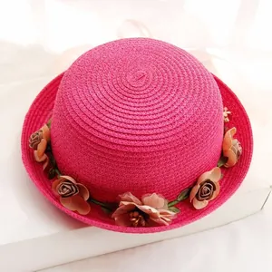 Deep pink straw sun hat with decorative fabric roses and a woven spiral texture