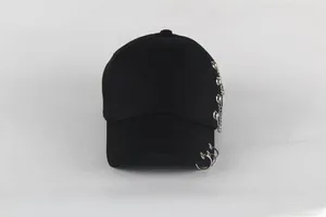 Detail of black cotton baseball cap featuring silver metal rings and punk chain elements