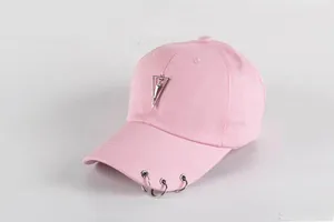 Detail of pink cotton baseball cap with silver metal rings and triangle pendant