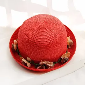 Bright red woven straw sun hat with decorative handmade floral accents for beach vacations