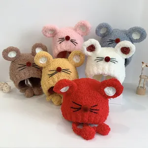 Détail de bonnets en peluche en forme de souris avec des oreilles et des pompons colorés