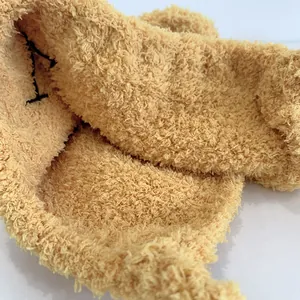 Gros plan sur le tissu pelucheux jaune clair avec broderie noire sur un bonnet d'enfant