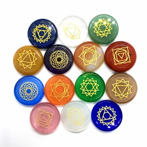 Macro view of 14 pieces flat round polished chakra stones with gold engraved symbols
