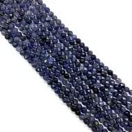 Vue rapprochée de perles d'iolite facettées 6mm montrant la texture de pierre naturelle bleue