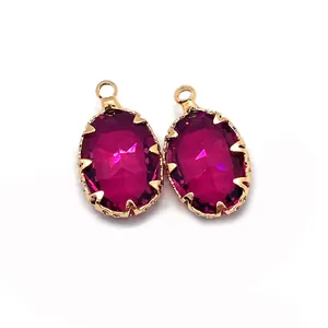 Dettaglio di ciondoli in cristallo rosso rosa sfaccettato con castoni in metallo dorato