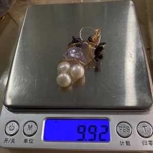 Vue macro montrant le poids d'un pendentif en cristal et perles fait main sur une balance