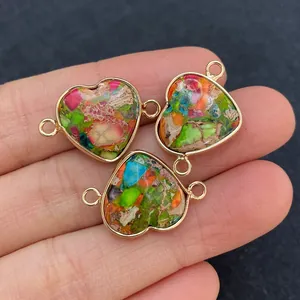 Detalle macro de tres colgantes de piedra natural en forma de corazón con bordes dorados
