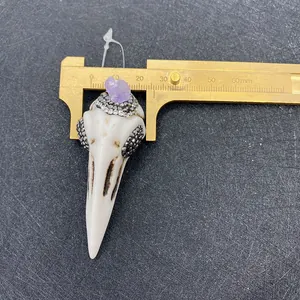 Detailmessung eines Vogel-Schädel-Anhängers mit Kristallen mittels Messschieber