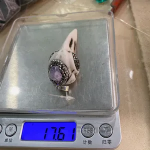 Nahaufnahme eines Vogelschädel-Anhängers mit Amethyst auf einer Feinwaage