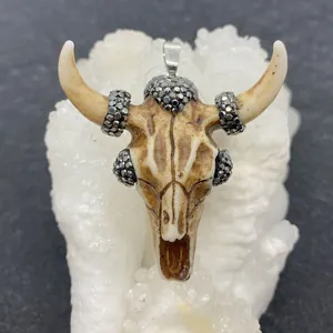 Macro view of acrylic bull skull pendant with inlaid rhinestones and silver metal clasp