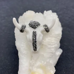 Macro shot of acrylic bull skull pendant with black diamond inlay on mineral crystals