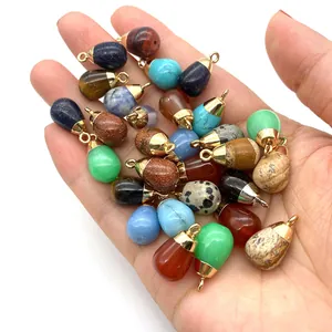 Mix of 20 natural teardrop stone pendants held in hand for jewelry making and DIY