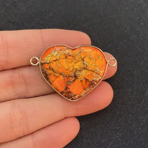 Macro detail of heart-shaped orange stone pendant with gold bezel and double loops