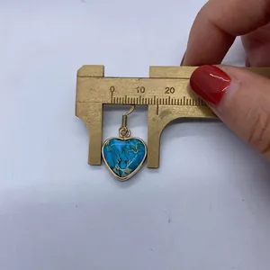 Measurement of 18mm heart-shaped blue turquoise earring with golden trim using caliper