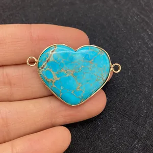 Heart-shaped turquoise stone pendant with gold-plated bezel and double ring connectors