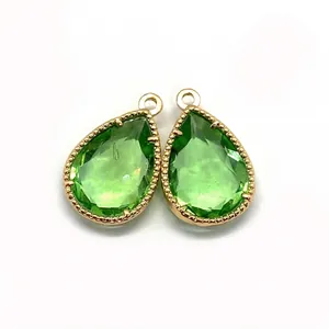 Detail of faceted green teardrop stone pendants with gold beaded metal edging for DIY