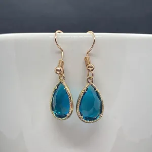 Close-up of deep blue faceted teardrop stone pendants with golden twisted wire frames