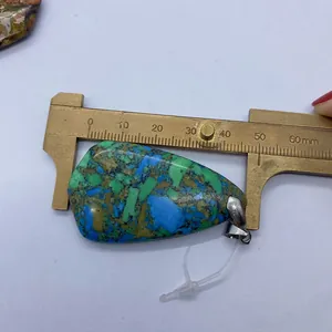 Vue macro mesurant un pendentif en pierre naturelle en goutte avec un pied à coulisse de 48mm