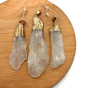 Tre pendenti irregolari in cristallo bianco con bordo dorato su vassoio di legno tondo