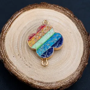 Macro shot of colorful imperial stone clover pendant with gold metal edges on wood