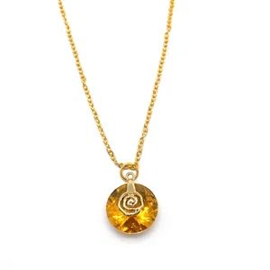 Macro view of faceted amber crystal pendant with gold rose center and gold chain