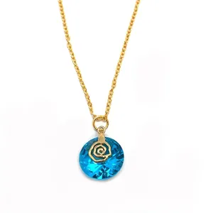 Detail of blue faceted crystal pendant with golden rose inlay on a fine gold chain