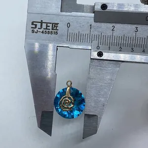 Detail view of 14mm faceted blue crystal round pendant with gold rose motif