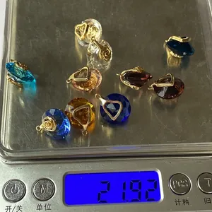 Macro shot of 14mm faceted natural stone pendants on a digital scale for weight display