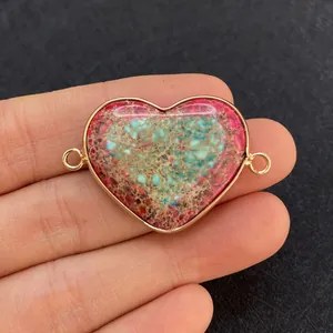 Macro view of heart-shaped natural stone connector with gold plating and dual loops