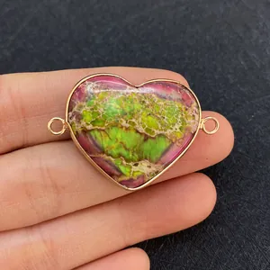 Macro shot of heart-shaped natural stone connector with gold trim and dual rings