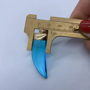 Close-up of translucent blue chili-shaped stone pendant measuring 13mm with gold bail
