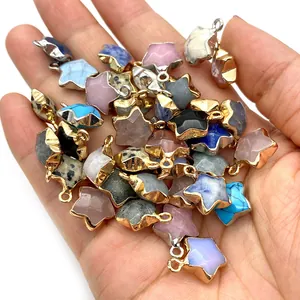 Pendentifs étoiles en pierre naturelle avec bordure métallique tenus dans la main